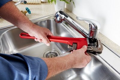 Plombier qui vérifie l'installation de robinet avant la remise en service